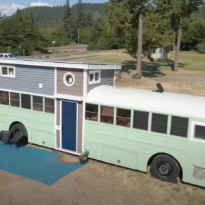 Young couple turn old bus into family home that houses 7 with addition of “tiny house” loft