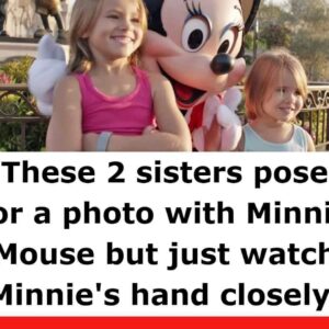 These two sisters pose for a photo with Minnie Mouse, but they keep a watchful eye on Minnie’s hand.